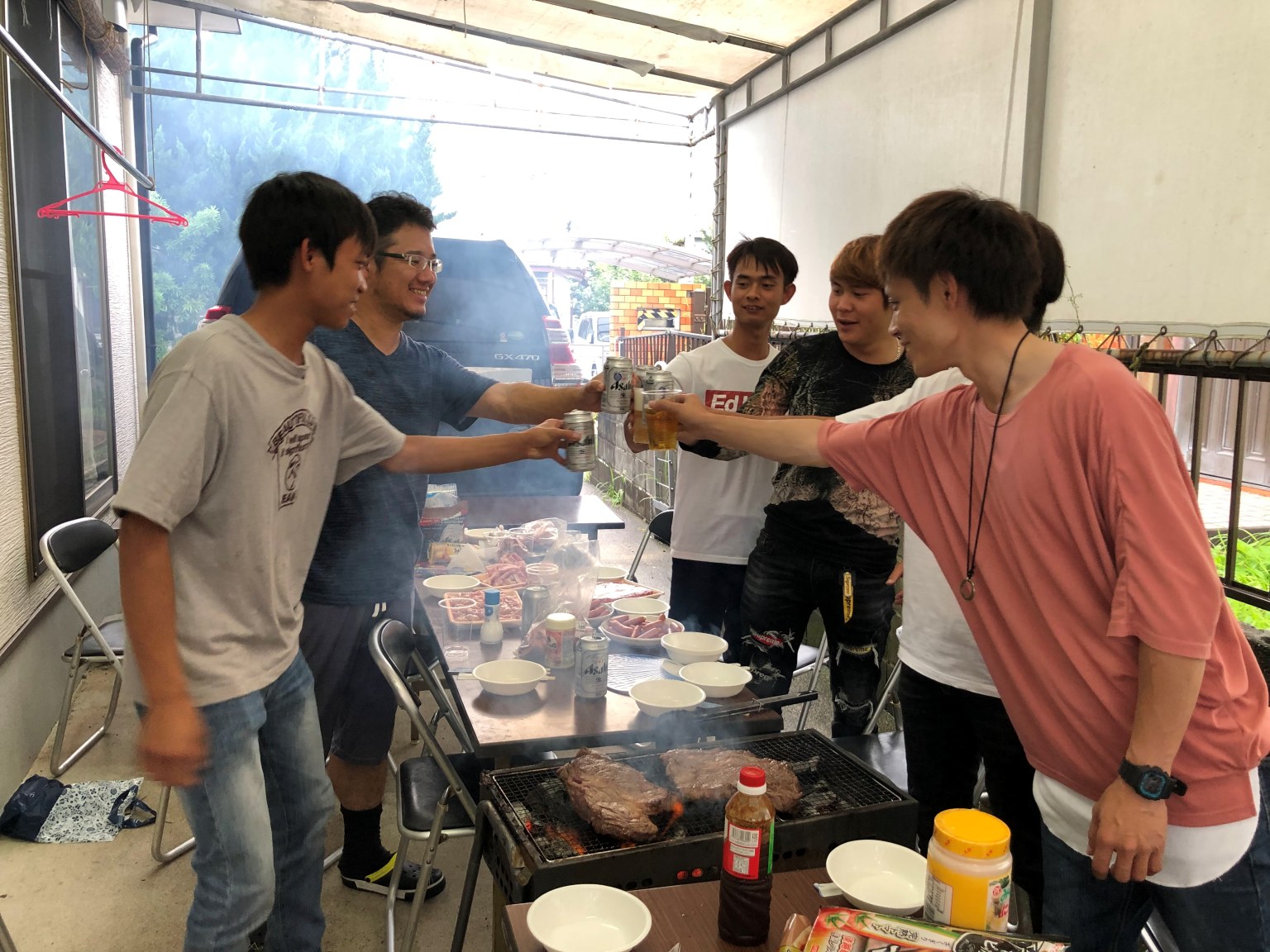 テーブルとイスを並べてバーベキューを楽しむ様子