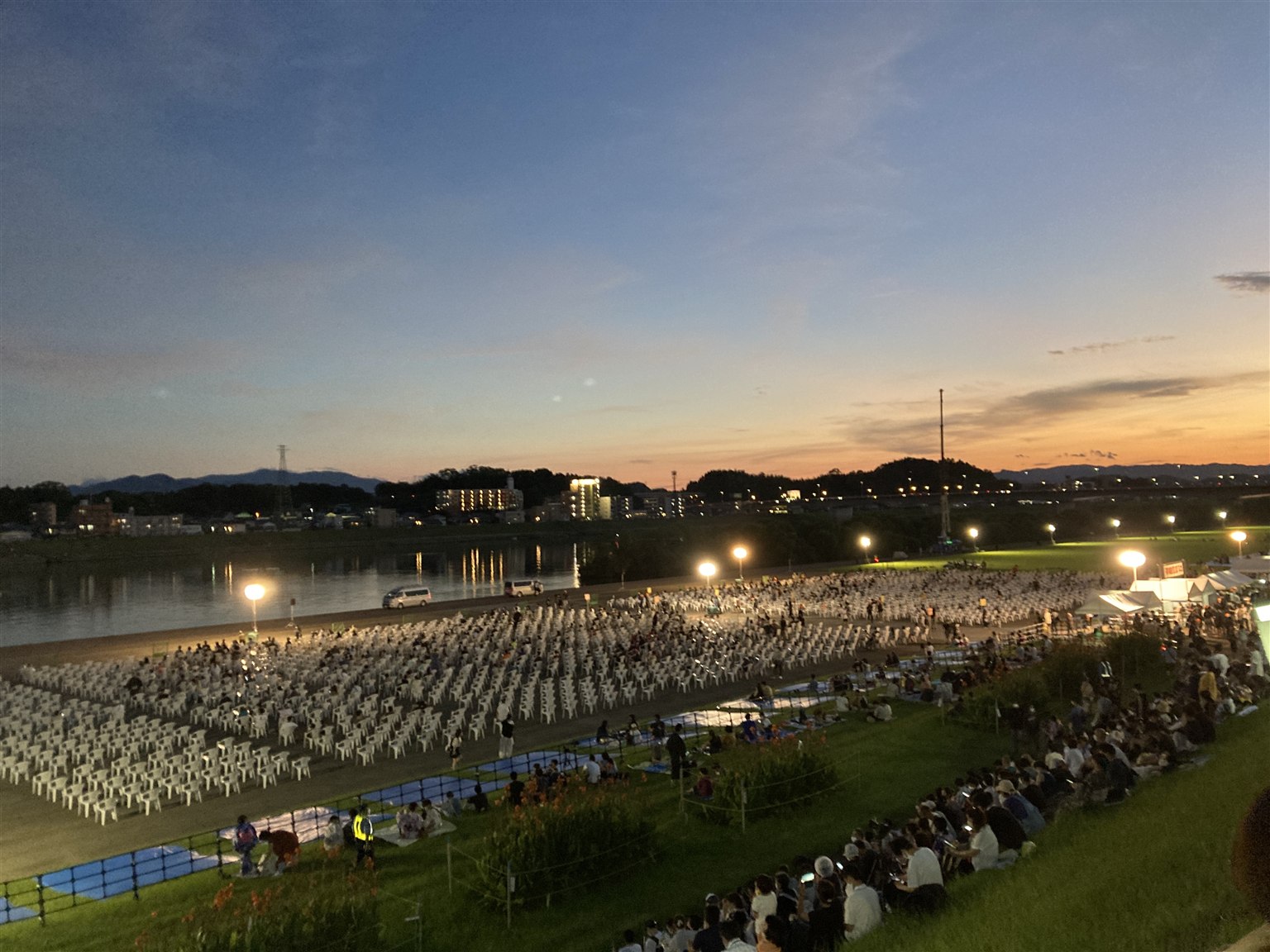 日没後、照明が点灯したみやざき納涼花火大会の会場と観覧席