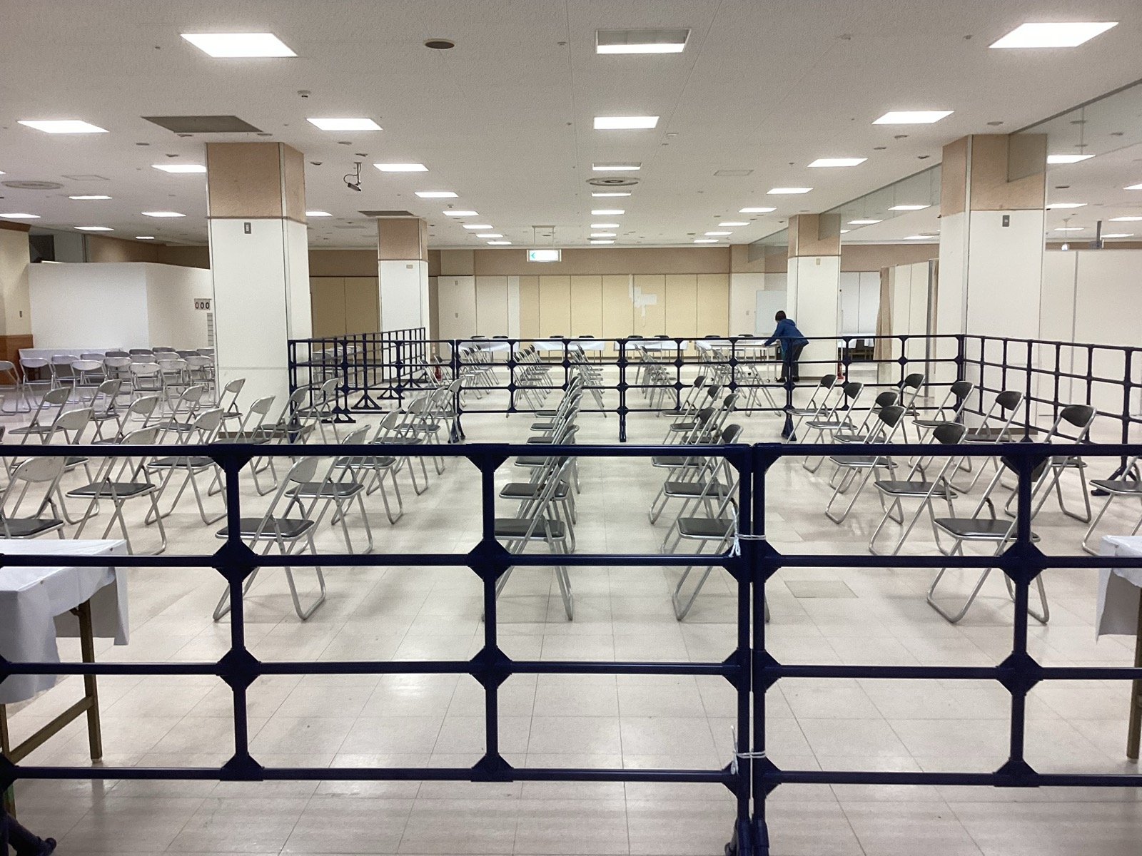 屋内の会場に並べた客席と、柵で区切った動線