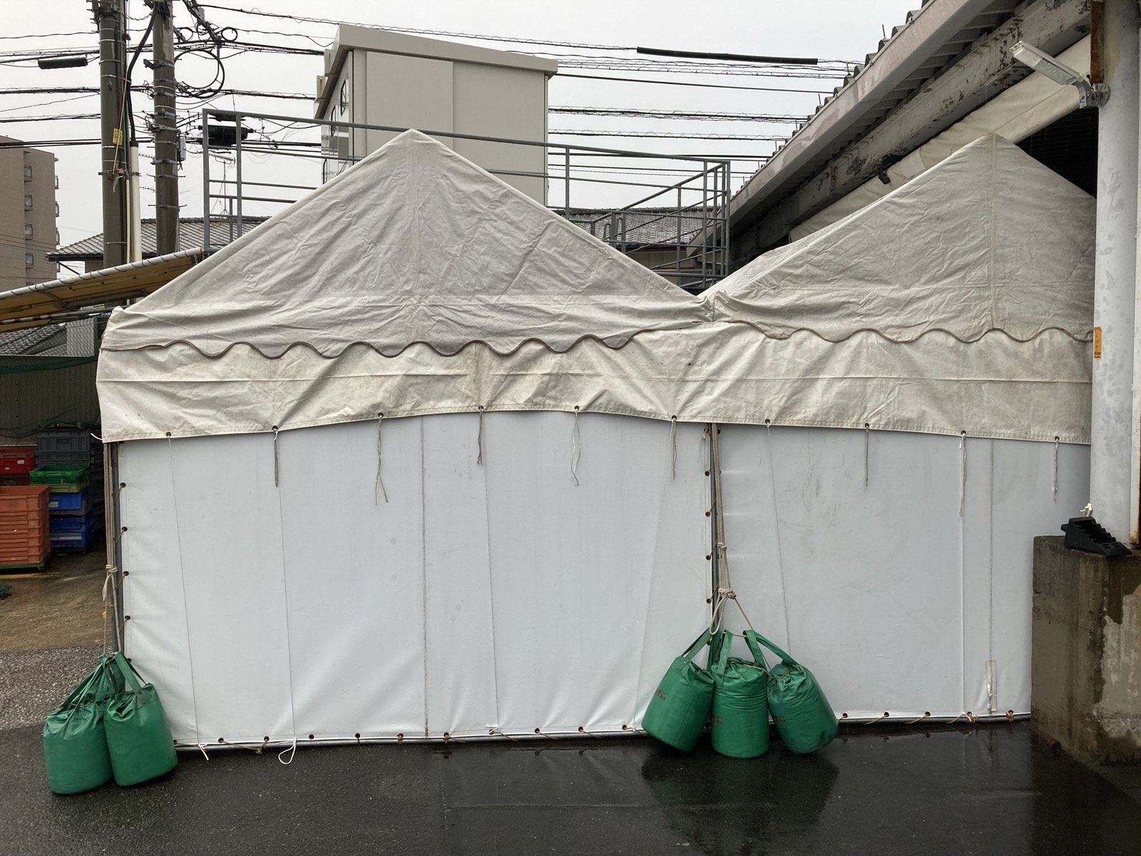 横幕を取り付け、砂袋のウエイトで固定したテント