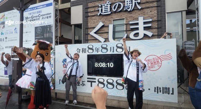 8時8分の瞬間、LED電波時計の前で万歳する、まつり888INくしまの参加者のみなさん