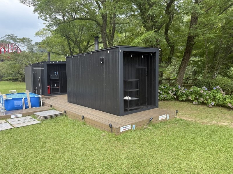 青井岳温泉グランサウナの外観と、緑に囲まれたウッドデッキ